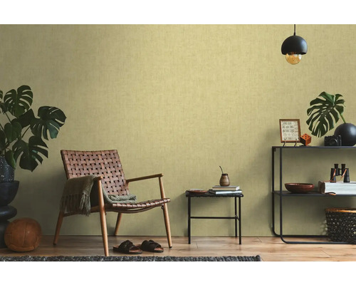 Wohnzimmer mit Sessel, Beistelltisch und Regal vor einer strukturierten Tapete
