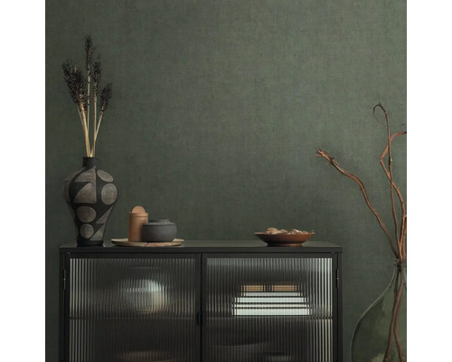 Dekoratives Sideboard mit Vasen und Schalen vor einer strukturierten Wand