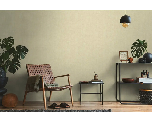 Wohnzimmer mit Rattansessel, Beistelltisch und Regal mit Dekorationen für eine wohnliche Atmosphäre.