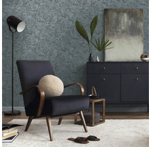 Wohnzimmer mit Sessel, Kommode, Stehlampe und gemusterter Tapete