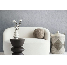 Dekoratives Wohnzimmerarrangement mit Sofa, Beistelltisch, Kissen und Korb
