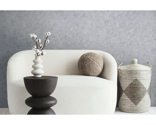 Dekoratives Wohnzimmerarrangement mit Sofa, Beistelltisch, Kissen und Korb