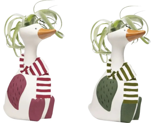 Zwei dekorative Gänsefiguren mit Schal und Pflanzen
