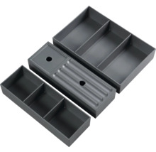 Drei graue Schubladeneinsätze mit Fächern zur Aufbewahrung von Gegenständen