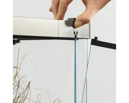 Detailaufnahme eines Aquariums mit Hand, die eine Abdeckung anbringt