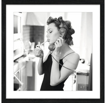 Schwarz-Weiß-Foto einer Frau mit Lockenwicklern, die ein Zigarette anzündet, während sie telefoniert, gerahmt