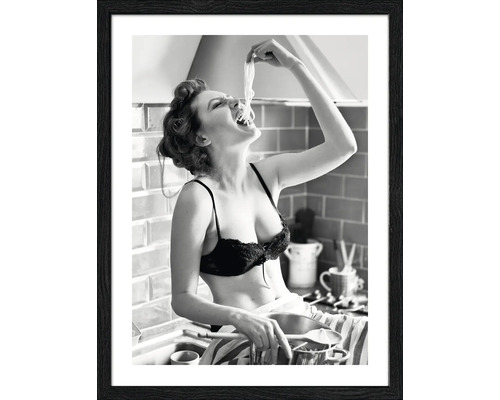 Schwarzweiß-Fotografie einer Frau, die in der Küche Spaghetti isst, gerahmt