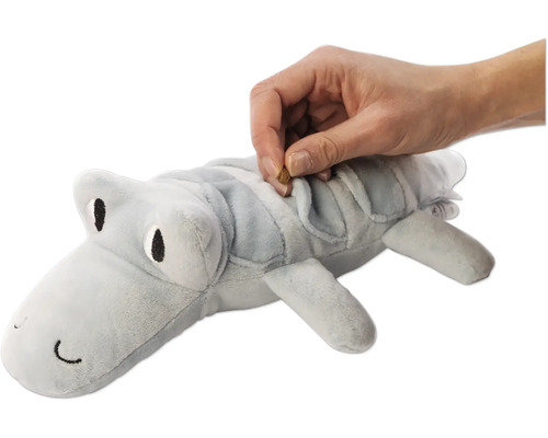 Graues Krokodil Plüschtier wird mit einem Leckerli gefüllt