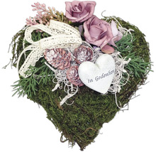 Herzförmiges Moosgesteck mit Rosen, Zapfen, Schleife und Herzanhänger mit der Aufschrift 'In Gedenken'