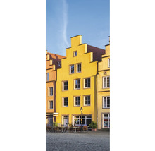 Gelbe Gebäude mit Fenstern und Tischen auf einem Platz