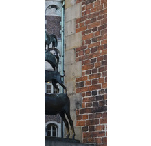 Skulptur der Bremer Stadtmusikanten vor einer Backsteinmauer.