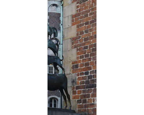 Duschrückwand SCHULTE DecoDesign Bremen rechts Bremer Stadtmusikanten 255 x 100 cm D190102523 8142 Skulptur der Bremer Stadtmusikanten vor einer Backsteinmauer.