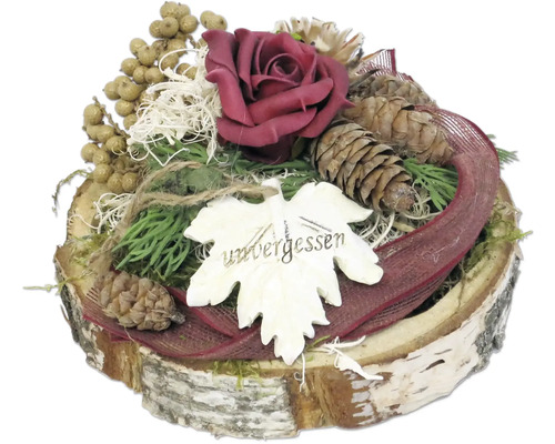 Gesteck mit Rose, Tannenzapfen, Beeren und einem Holzschild mit der Aufschrift 'unvergessen'.