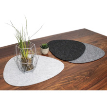 Dekoratives Arrangement mit Filzplatzsets, Topfpflanze und geometrischem Drahtgestell auf Holztisch