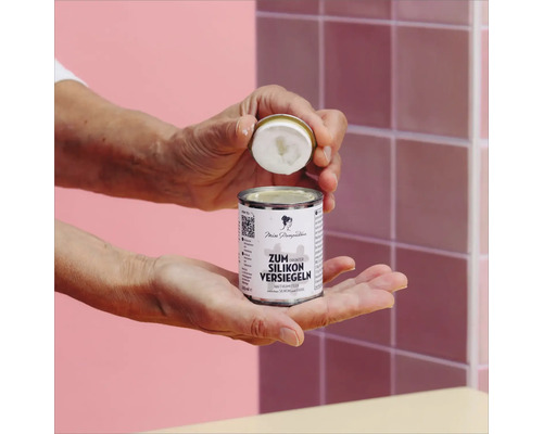 Geöffnete Dose Silikonversiegelung in der Hand