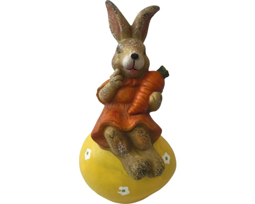 Dekorative Hasenfigur mit Karotte auf gelbem Ei für die Osterzeit