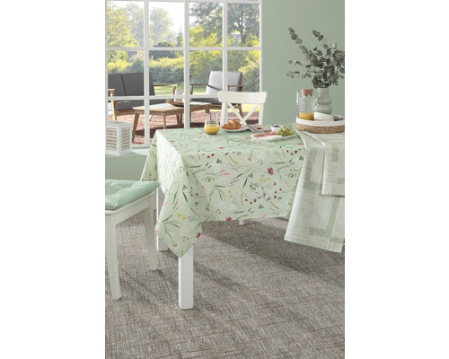 Gedeckter Tisch mit floraler Tischdecke in einem hellen Raum