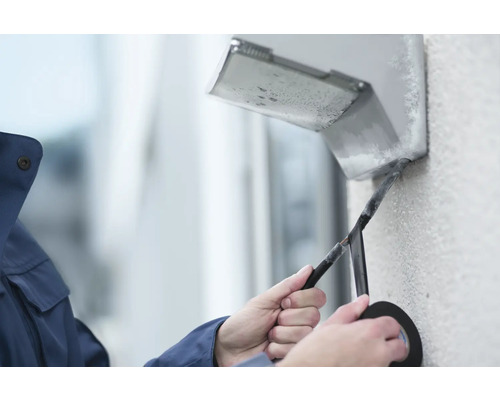 Elektriker isoliert Kabel mit Isolierband an Außenlampe