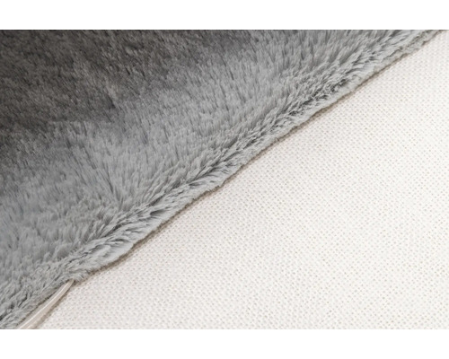 Detailaufnahme einer grauen Kuscheldecke mit weißer Unterseite.