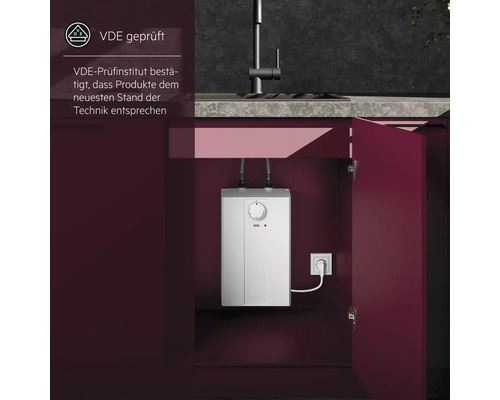 Elektrischer Warmwasserbereiter von AEG im Küchenschrank mit geöffneter Tür und VDE geprüft Siegel.
