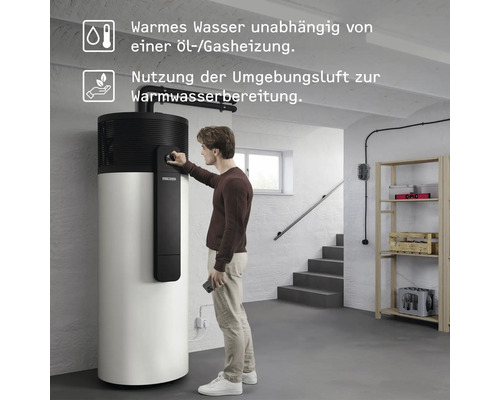 Mann bedient eine Warmwasser-Wärmepumpe im Keller zur Warmwasserbereitung.