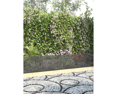 Garten mit Bewuchs, Metallzaun und Mosaikpflaster