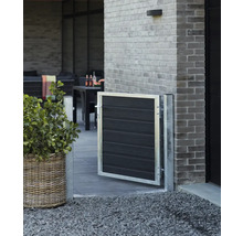 Gartenszene mit einem kleinen Tor aus Metall und Holz, einem Pflanzgefäß und einer Terrasse