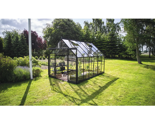 Gewächshaus aus Glas mit Stahlrahmen im Garten.
