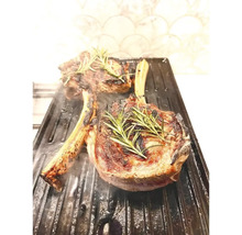 Zwei Tomahawk Steaks auf einer Grillplatte mit Rosmarin garniert