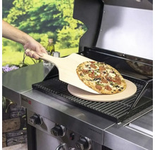Pizza auf Holzschaufel über Pizzastein auf Grill