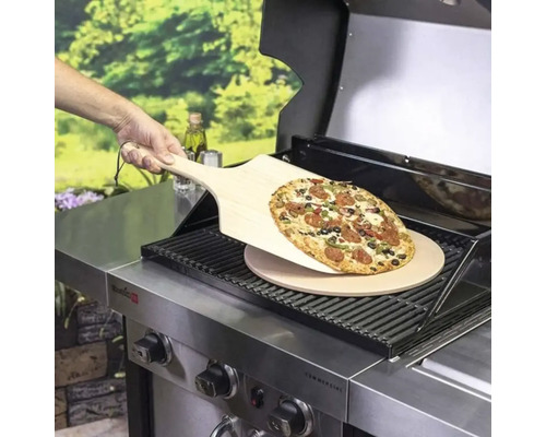 Pizza auf Holzschaufel über Pizzastein auf Grill