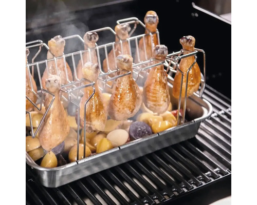 Grill mit Hähnchenschenkelhalter und Kartoffeln.