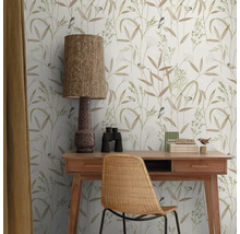 Dekoratives Arbeitszimmer mit Schreibtisch, Stuhl, Lampe und Tapete mit Pflanzen- und Vogelmuster