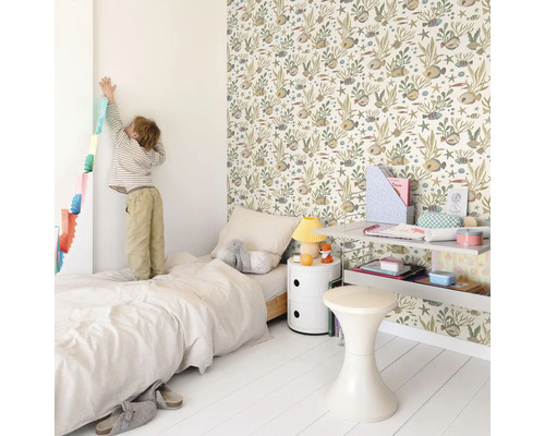 Helles Kinderzimmer mit Bett, Nachttisch, Regal, Hocker und einer Wand mit Tiermuster-Tapete.