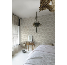 Schlafzimmer mit gemusterter Tapete, Bett, Nachttisch und Zimmerpflanze