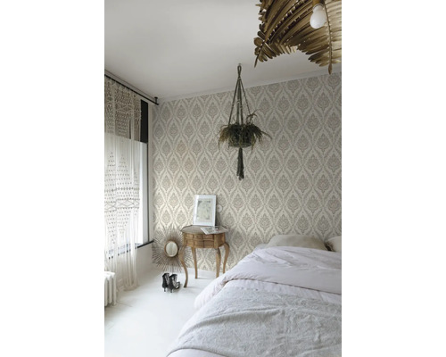 Schlafzimmer mit gemusterter Tapete, Bett, Nachttisch und Zimmerpflanze