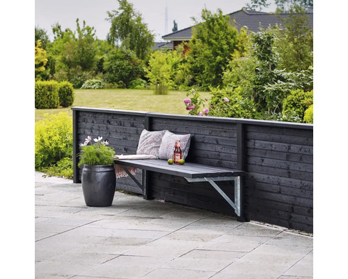 Garten Szene mit Holzbank an Holzzaun, Dekokissen, Getränk und Pflanztopf.