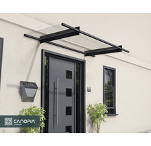 Modernes Haustürvordach mit schwarzem Aluminiumrahmen und transparenter Abdeckung über einer grauen Eingangstür. Canopia Logo.