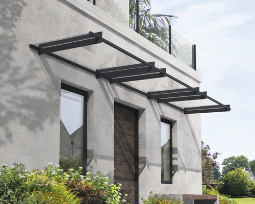 Modernes Vordach mit dunklem Metallrahmen und transparenten Paneelen über Haustür und Fenstern an einer grauen Steinfassade.