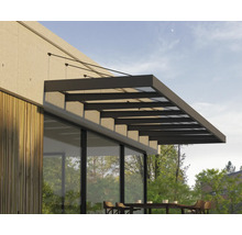 Modernes Terrassendach aus Glas und dunklem Metall montiert an einer Hauswand mit Holzverkleidung über einem Sitzbereich im Freien.