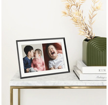 Schwarzer Bilderrahmen mit Fotos auf einem Tisch