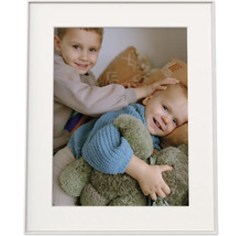 Bilderrahmen mit Passepartout und einem Foto von zwei lächelnden Kindern mit einem Kuscheltier.