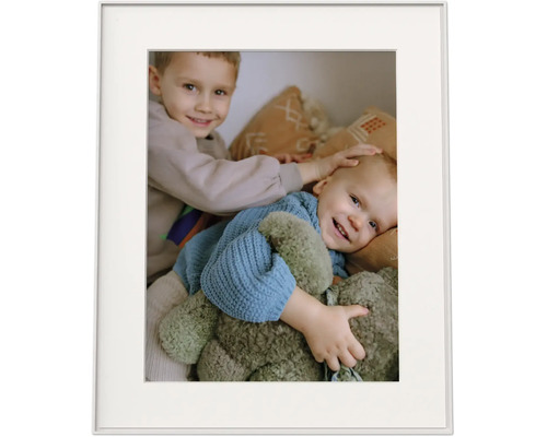Bilderrahmen mit Passepartout und einem Foto von zwei lächelnden Kindern mit einem Kuscheltier.