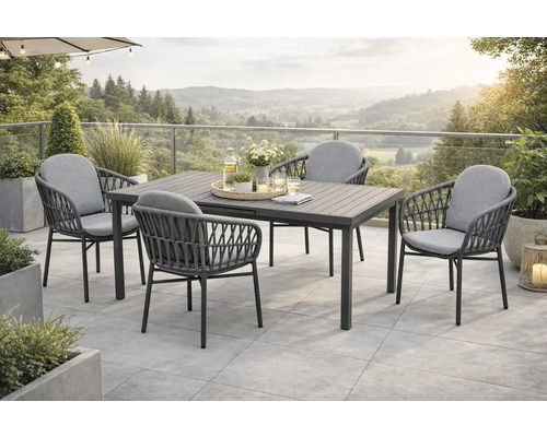 Gartenszene mit Esstisch und vier Stühlen auf einer Terrasse mit Blick auf die Landschaft