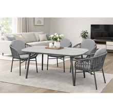 Esstischgruppe mit Tischplatte in Steinoptik und vier Stühlen mit gewebter Rückenlehne in einem hellen Wohnraum.