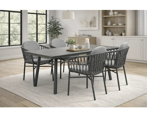 Esstischgarnitur mit vier Korbstühlen und grauem Holztisch in einem hellen Raum.