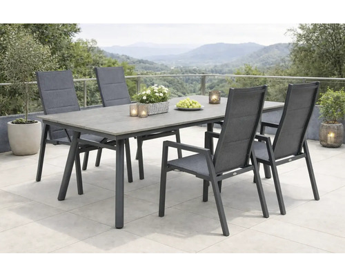 Gartenszene mit Esstisch und vier Stühlen auf einer Terrasse mit Bergblick