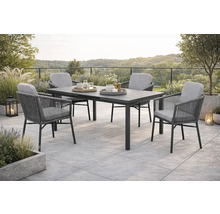 Gartenszene mit Esstisch und vier Stühlen auf einer Terrasse.