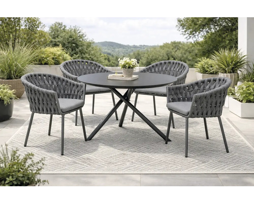 Gartensitzgruppe mit rundem Tisch und vier Stühlen auf einem Teppich im Freien.