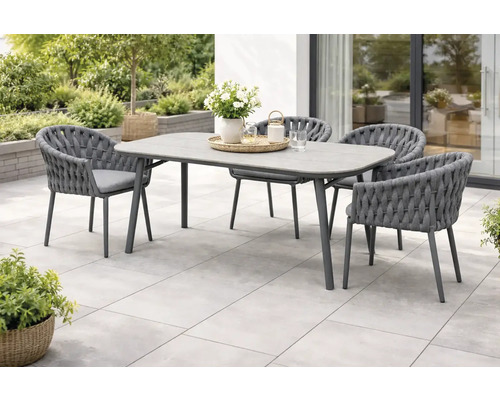 Gartenszene mit Esstisch und vier Stühlen im Freien.